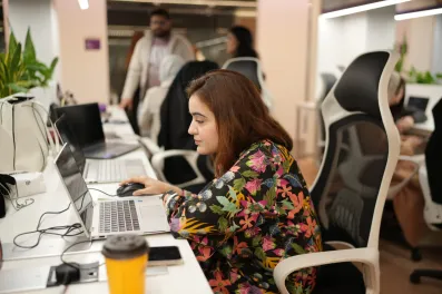 Associate working at desk in open office.