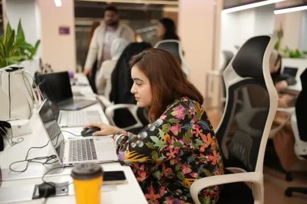 Associate working at desk in open office.