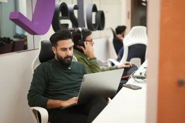 Two associates working at desks in open office, illustrating local hiring costs