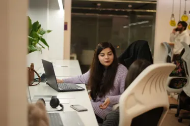 Employee working at desk in open office.