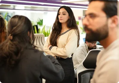 Team members standing together in office discussion.